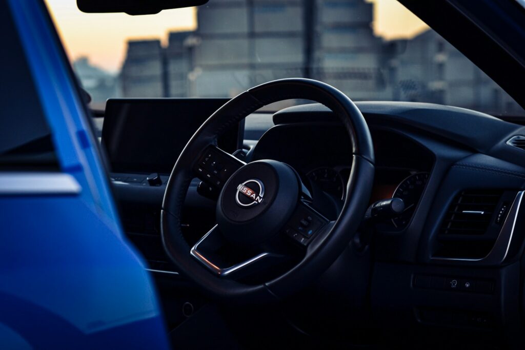 the interior of a Nissan Qashqai with a steering wheel and dashboard